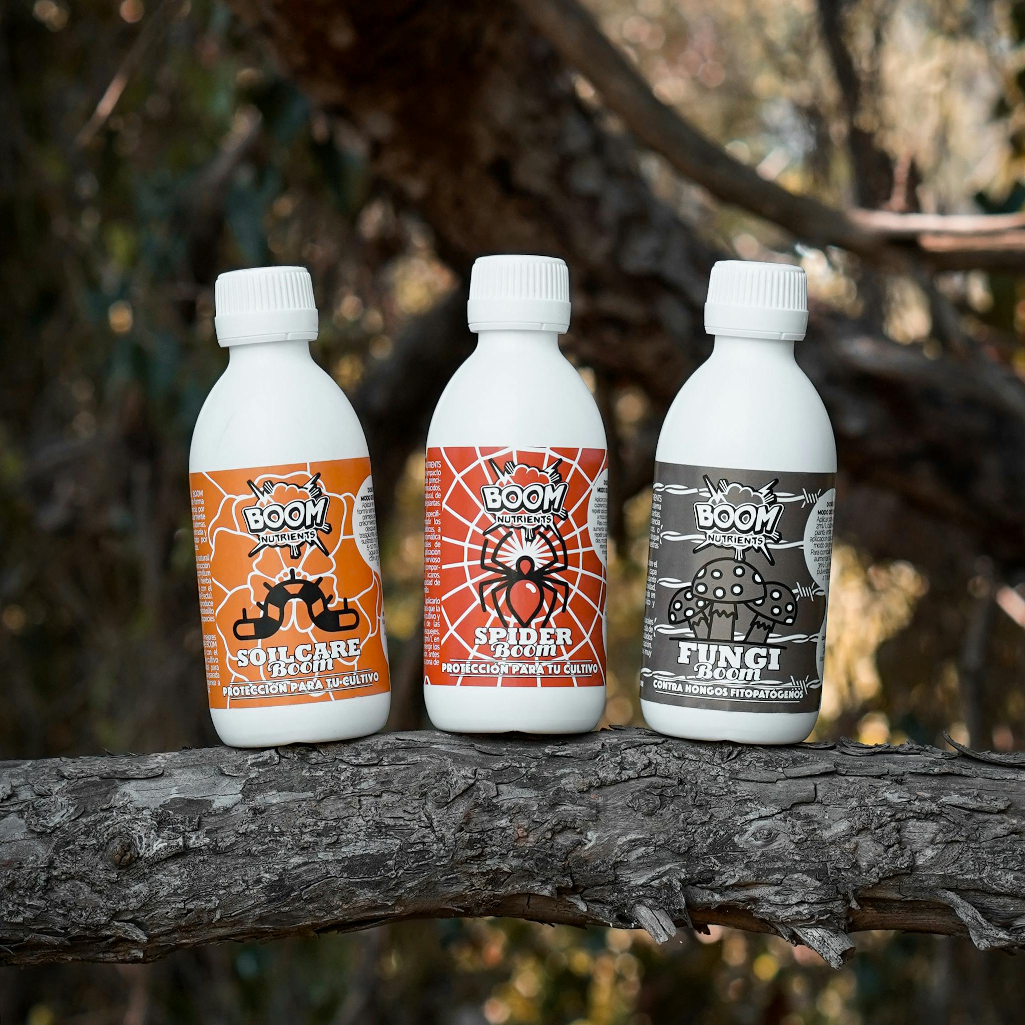 Three eco-friendly garden product bottles displayed on a tree branch outdoors.
